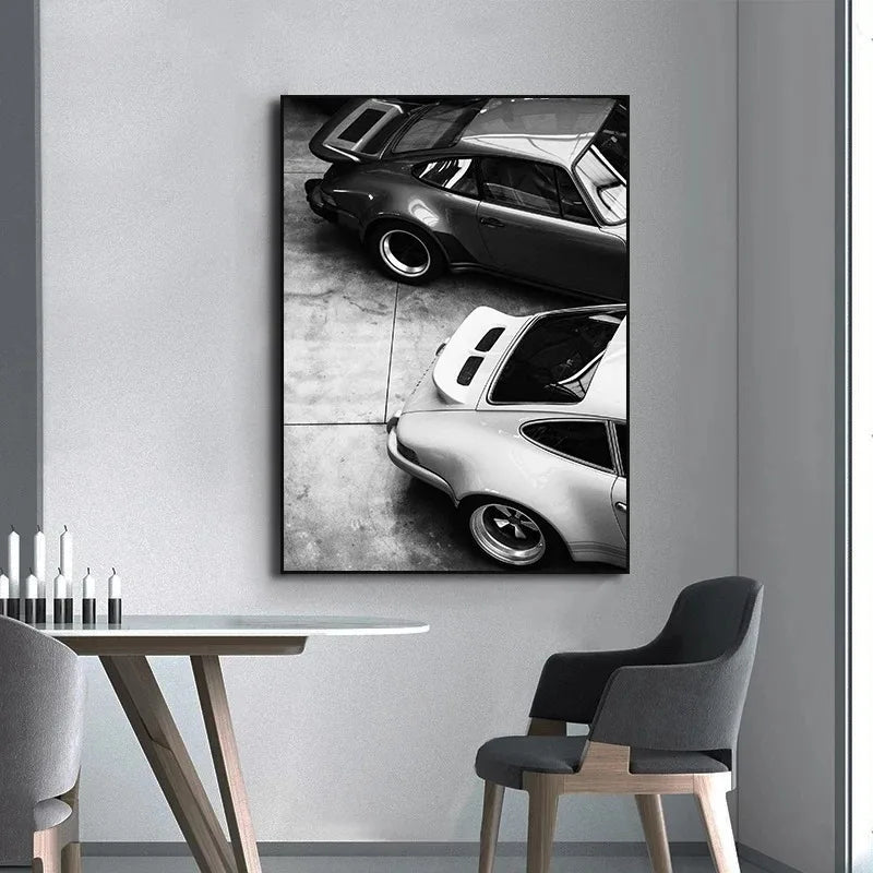 Schwarz-weißes Leinwandbild mit zwei Luxusautos auf einem Betonboden.
