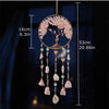 A hanging crystal tree of life sun catcher wall decor featuring pink floral branches and dangling crystals.