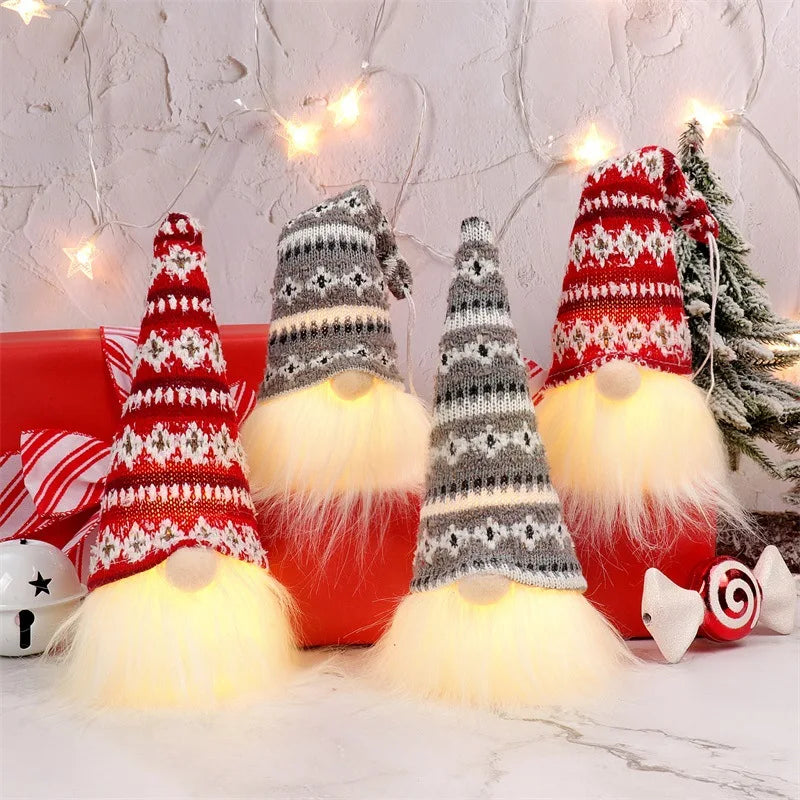 A display of illuminated LED gnome Christmas decorations featuring faceless dolls with warm glow and festive red and white pa