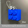 Blue magnetic absorption box with wires and small toys mounted on a gray wall.