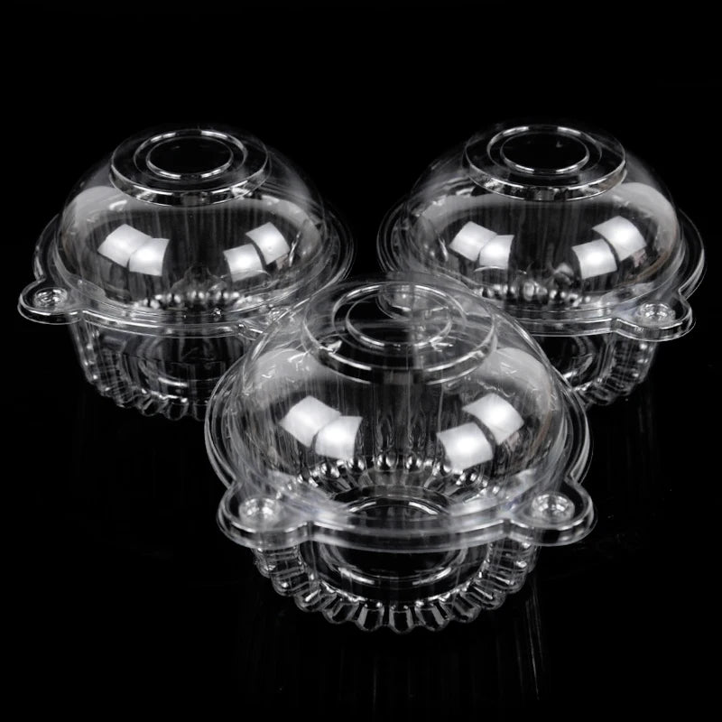 A set of clear plastic cupcake boxes with lids displayed against a black background.