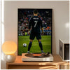 A framed poster of Cristiano Ronaldo in a dark jersey standing on a soccer field, displayed next to a pool table.
