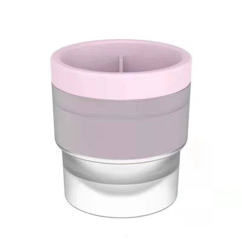A stackable spherical ice mold for whiskey and cocktails with a pink and clear design.