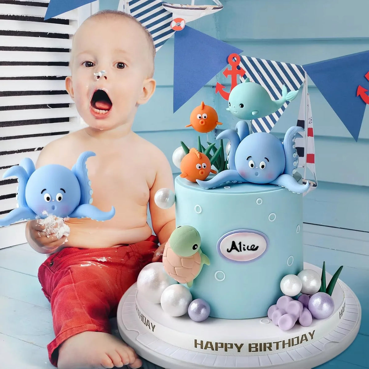 A light blue cake decorated with sea animals and pearl balls for a birthday party theme.