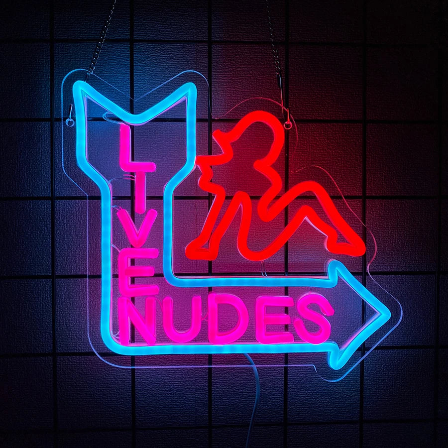 Neon wall sign featuring a silhouette of a woman and the word NUDES in bright pink and blue neon tubing.