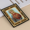 A framed icon of the Virgin Mary with a halo and St. Michael, featuring gold detailing on a black frame.