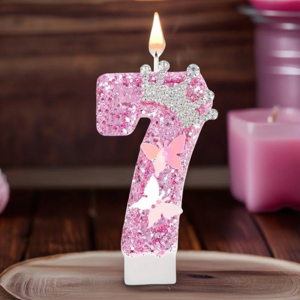 A pink glitter candle shaped like the number 7 decorated with butterfly accents