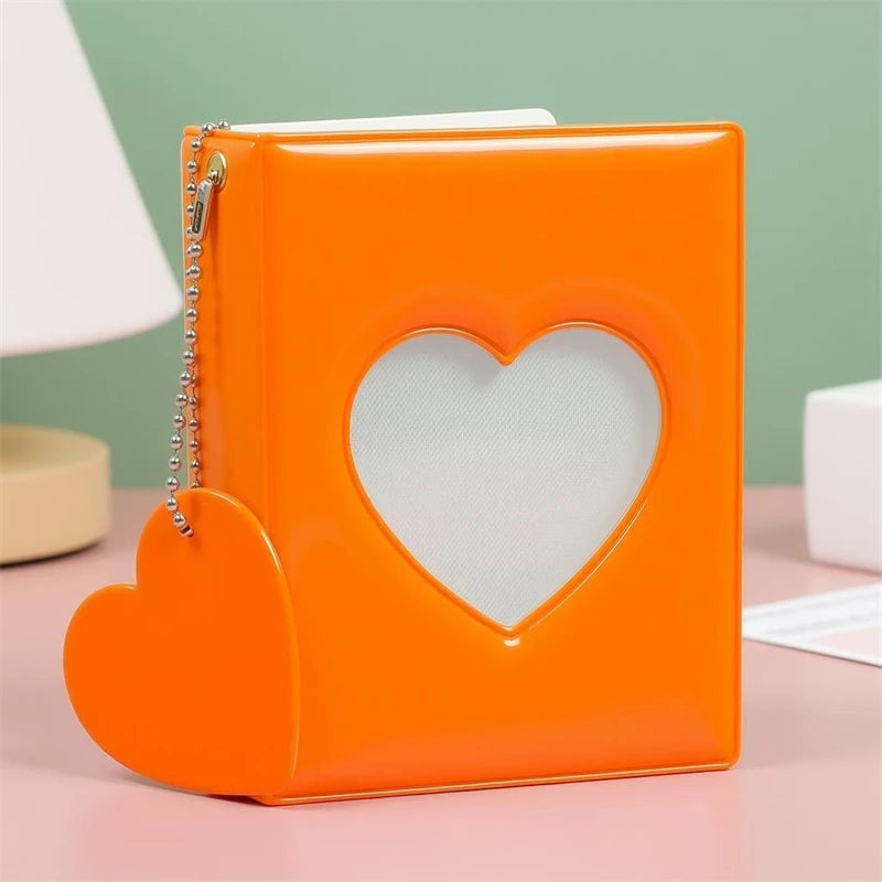 An orange candy heart window photocard album with a heart-shaped cutout on the front.