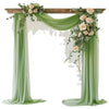 Elegant sage green chiffon drapes forming an arch backdrop for a wedding or event.