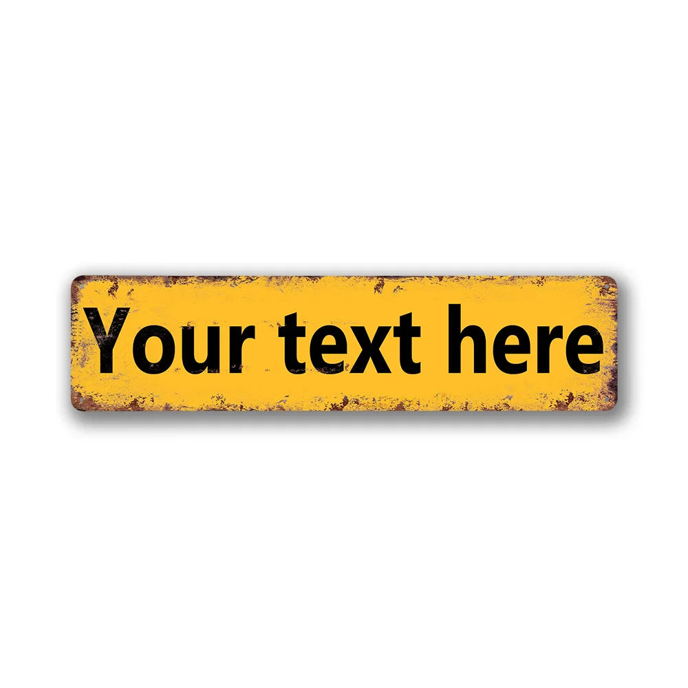 A rectangular vintage yellow tin sign with black text that reads Your text here.