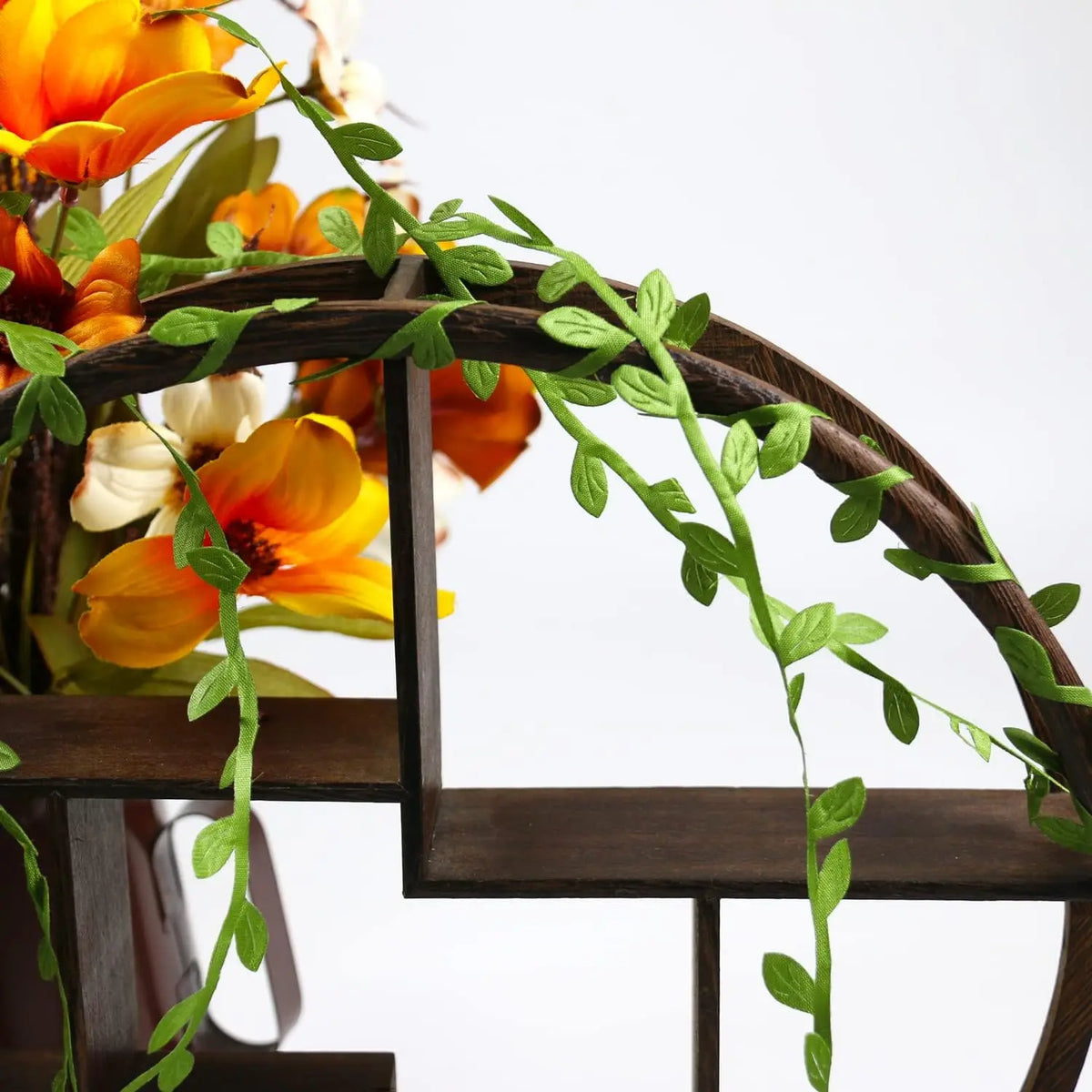 Artificial green climbing vine with orange and yellow flowers decorating a dark wooden chair frame