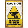 A vintage yellow and black caution sign warning about 24 hours of video surveillance.