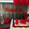 Red heart-shaped foil balloons spelling out I LOVE YOU hanging in a room