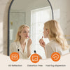 A woman is looking in an arched wall-mounted bathroom mirror, demonstrating HD reflection and distortion-free viewing.