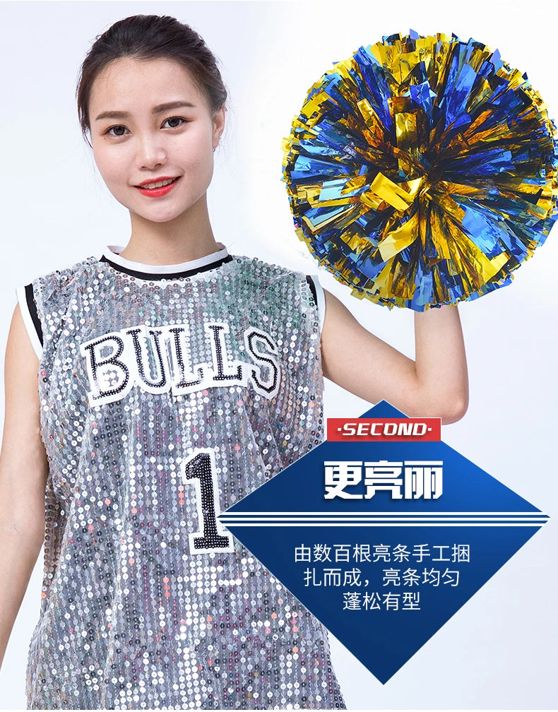 A young woman wearing a sports jersey is holding a bright blue and yellow pom pom in her hand.