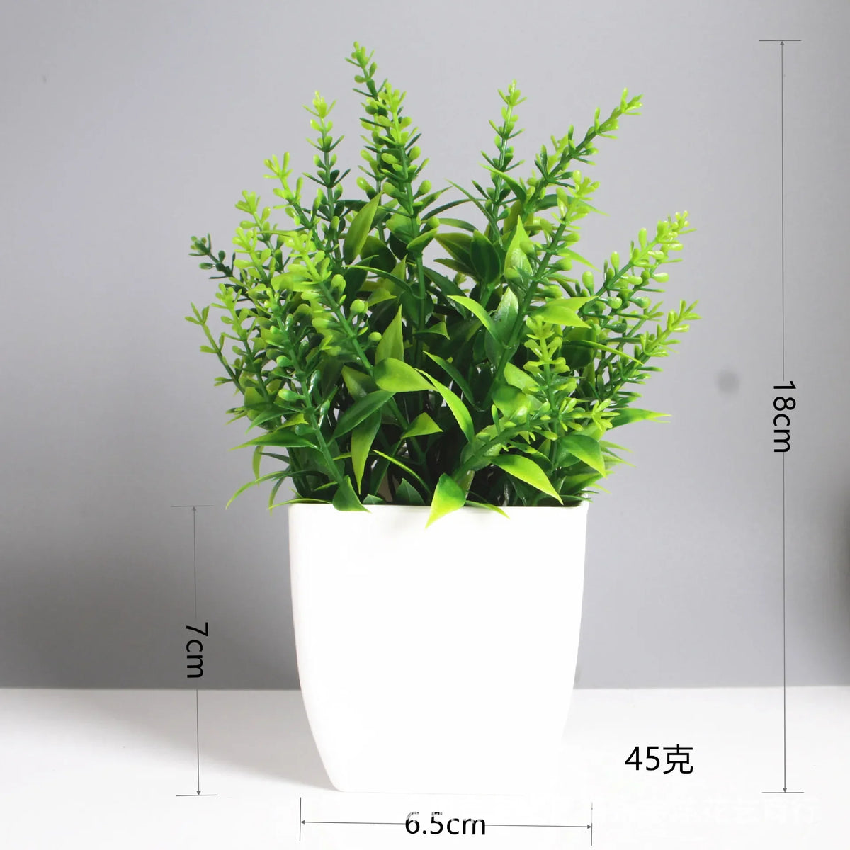 A potted artificial bonsai plant with bright green eucalyptus leaves in a white cylindrical pot.