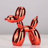 A shiny copper-colored resin sculpture shaped like a dog, used as whimsical home decor.