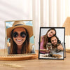 A modern metal and acrylic photo frame displaying a smiling woman wearing a straw hat and sunglasses.