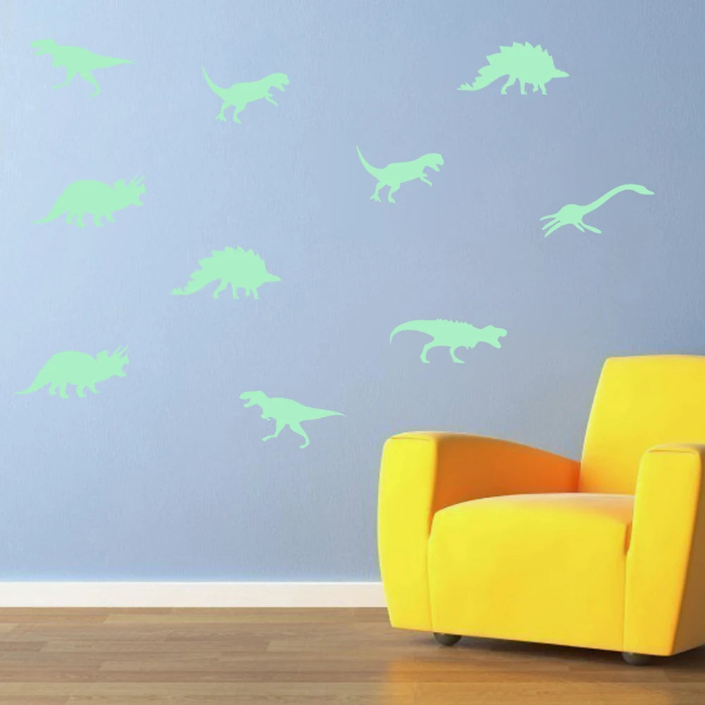 A bright yellow armchair sits in front of a light blue wall decorated with green dinosaur silhouettes.