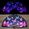 A folding fan with a UV fluorescent design featuring colorful butterflies and iridescent light patterns.