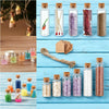 A collection of mini glass bottles with cork stoppers filled with various colored crystals and natural materials for crafts a