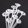 White macaron balloon sticks with holder cups arranged vertically against a dark background