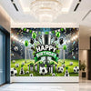 A football themed birthday backdrop banner featuring a trophy, crowns, and green balloons on a green field.