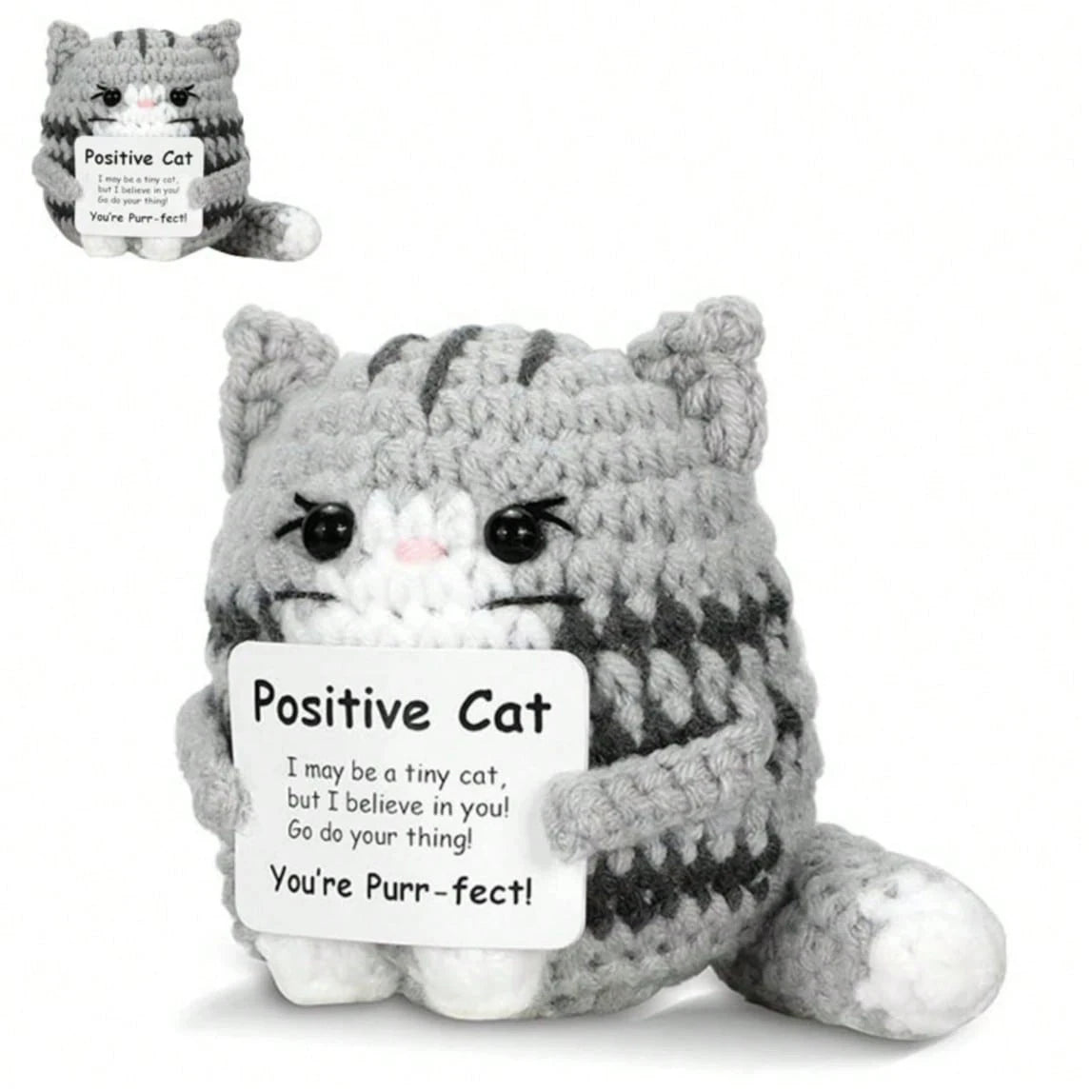 A handmade gray and white crochet mini cat plush toy with a tag that reads Positive Cat