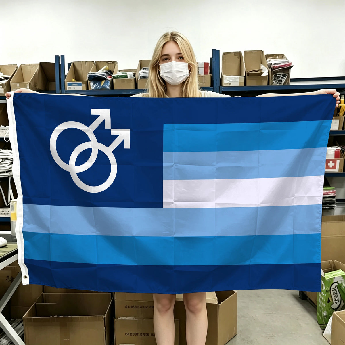 A person holds up a dark blue and light blue Pride flag banner with white symbols and stripes in a warehouse setting.