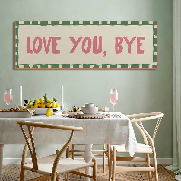 A framed canvas art print featuring the text LOVE YOU BYE in pink lettering on a light background with a green checkered bord