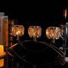 A three-arm gold crystal candelabra with glowing candles displayed against a dark background.