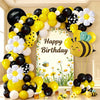 A large balloon arch set featuring yellow, black, and white balloons shaped like bees and daisies.