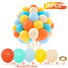 A pile of 36 assorted colored balloons in yellow, orange, blue, and white for party decor.