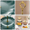 A set of three tiered plastic dessert stands in gold and dark green colors.