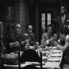 Scène en noir et blanc du film Scarface avec plusieurs hommes assis à une table.