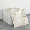 A rectangular slab of white marble with natural veining is displayed on a gray surface.