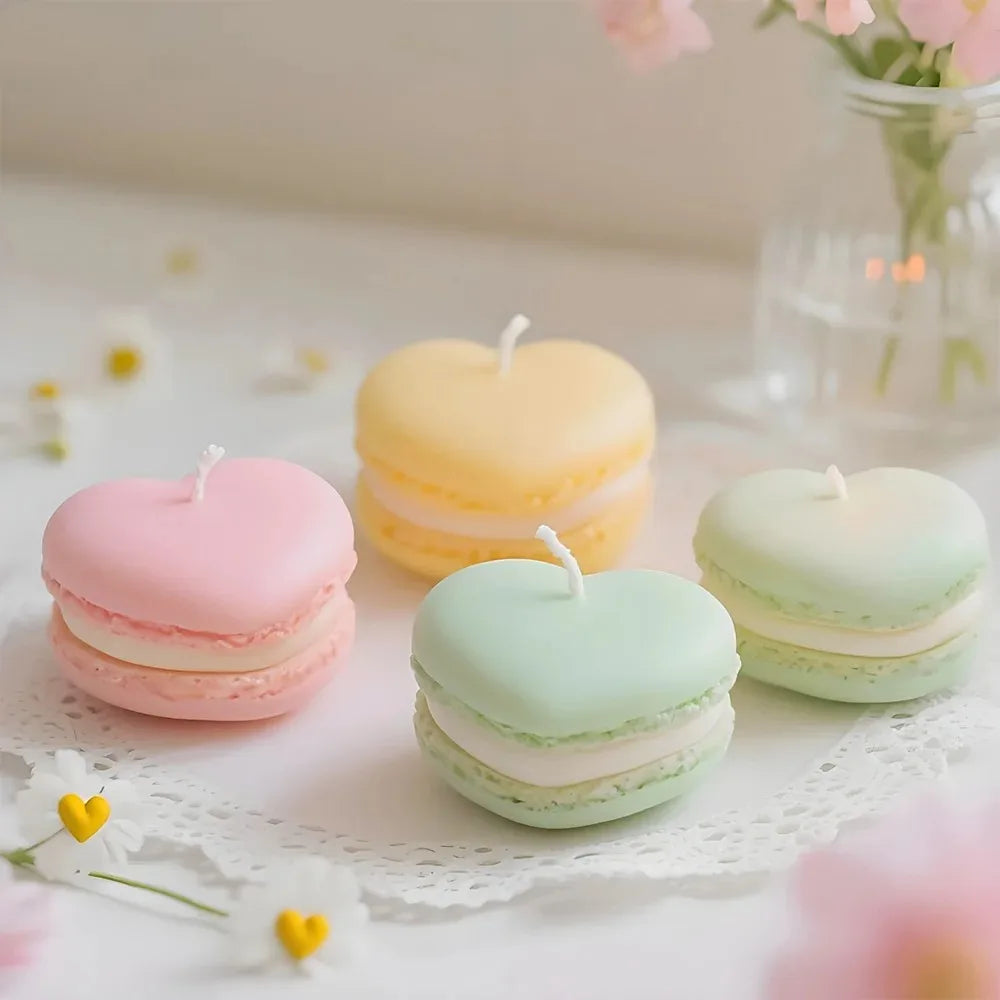 Three pastel colored macaron-shaped soy wax candles arranged on white lace with soft pink and yellow flowers.