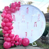 A large white balloon display featuring pink latex balloons tied with ribbons for party decorations.