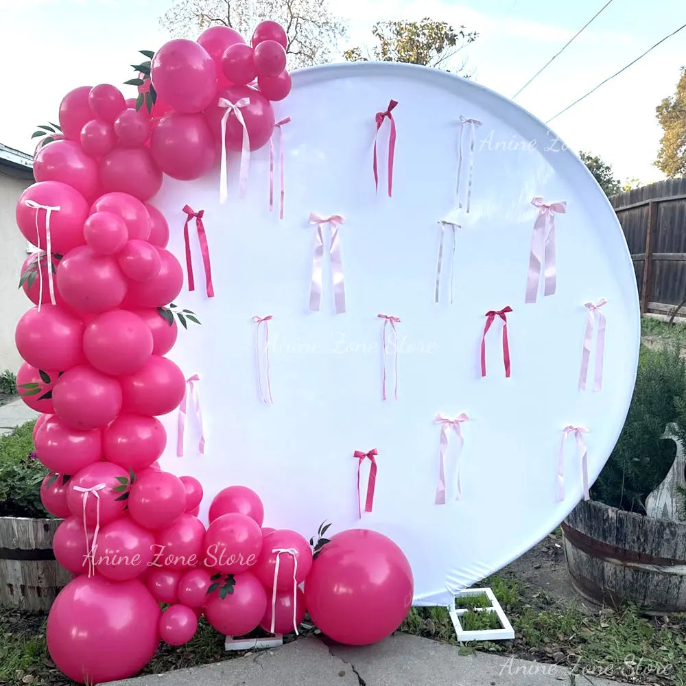 A large white balloon display featuring pink latex balloons tied with ribbons for party decorations.