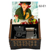 A hand-cranked wooden music box featuring characters from Once Upon a December, set against a snowy background.