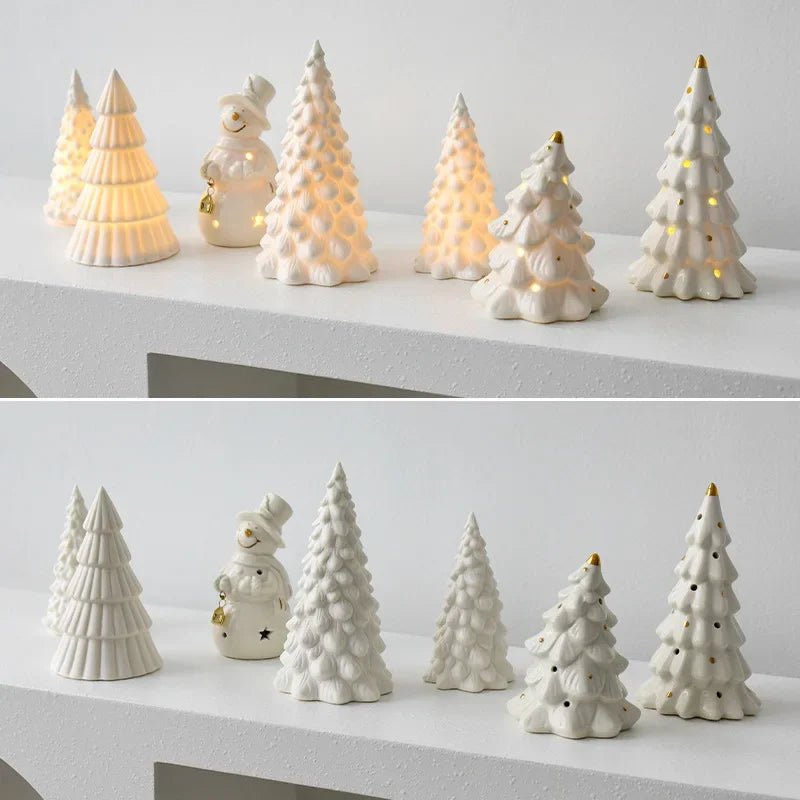 A collection of ceramic glow-in-the-dark mini Christmas tree decor in white and yellow shades arranged on a white surface.