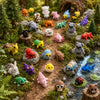 A collection of multi-animal 3D printed figurine ornaments in various colors and textures set in a natural outdoor environmen