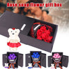 A gift box containing a rose soap bouquet and a plush bear, with additional floral arrangements visible.