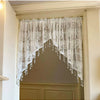 A sheer white beaded lace valance curtain with a scalloped edge hangs in a recessed doorway.