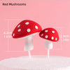 Two red mushroom cake toppers with white stems and white polka dots on a white cake.