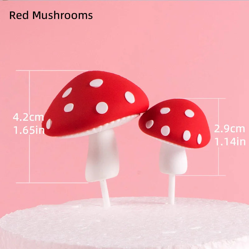 Two red mushroom cake toppers with white stems and white polka dots on a white cake.