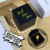 Une boîte cadeau noire avec des lettres dorées indiquant « Just for you » sur une surface en bois.