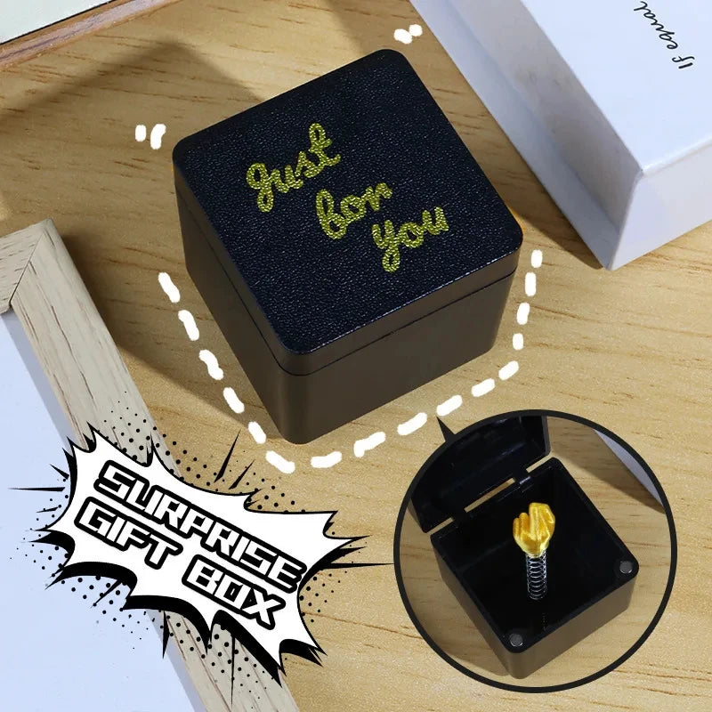 Une boîte cadeau noire avec des lettres dorées indiquant « Just for you » sur une surface en bois.