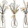 Set of three rustic metal flower arrangements in glass bottles with dried flowers and greenery