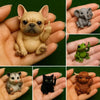 A collection of small resin animal statues including a fawn dog, an elephant, a frog, a mouse, a cat, and a baby lion.